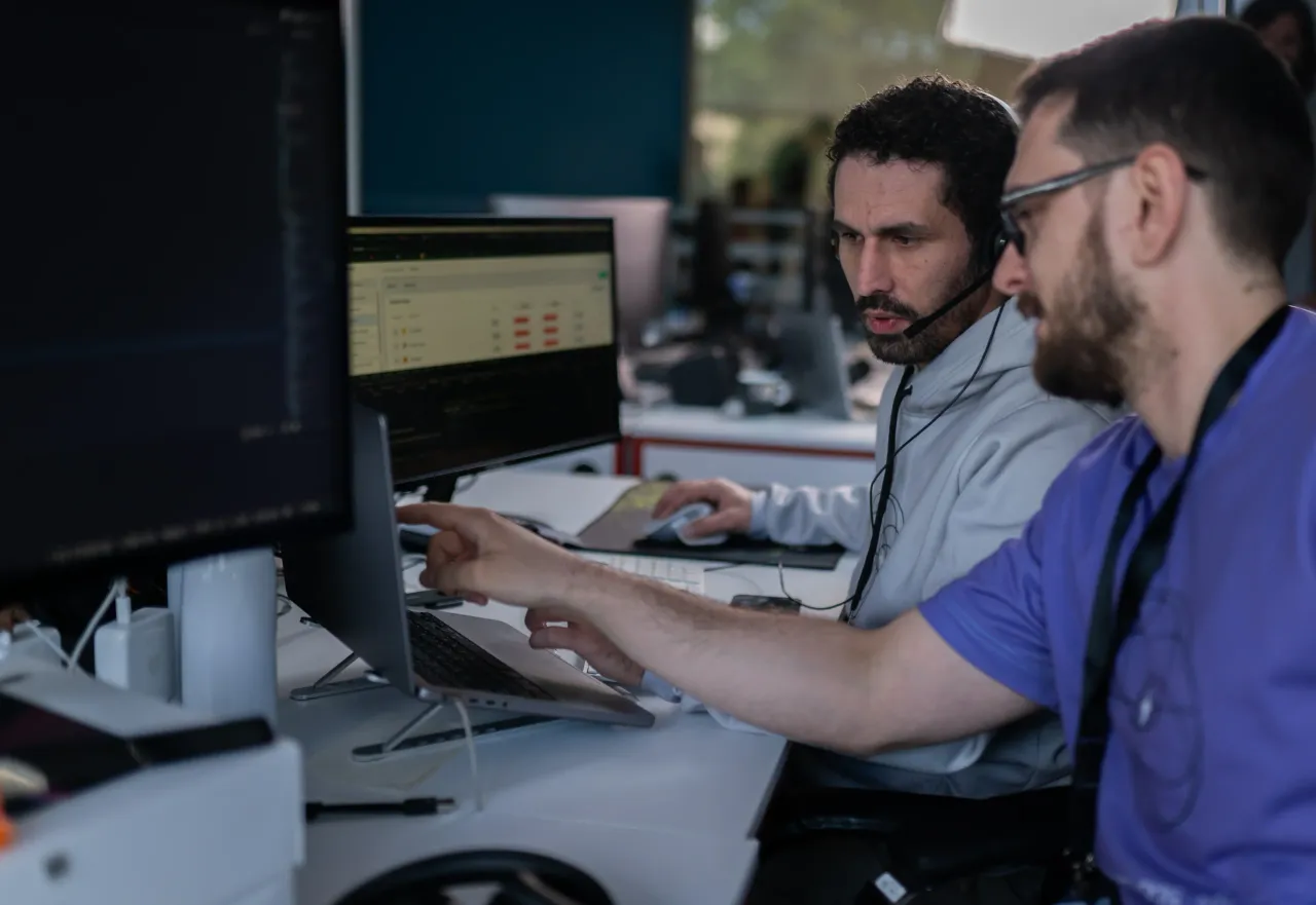 A StarLabs colleague wearing a headset and reviewing a screen with a teammate