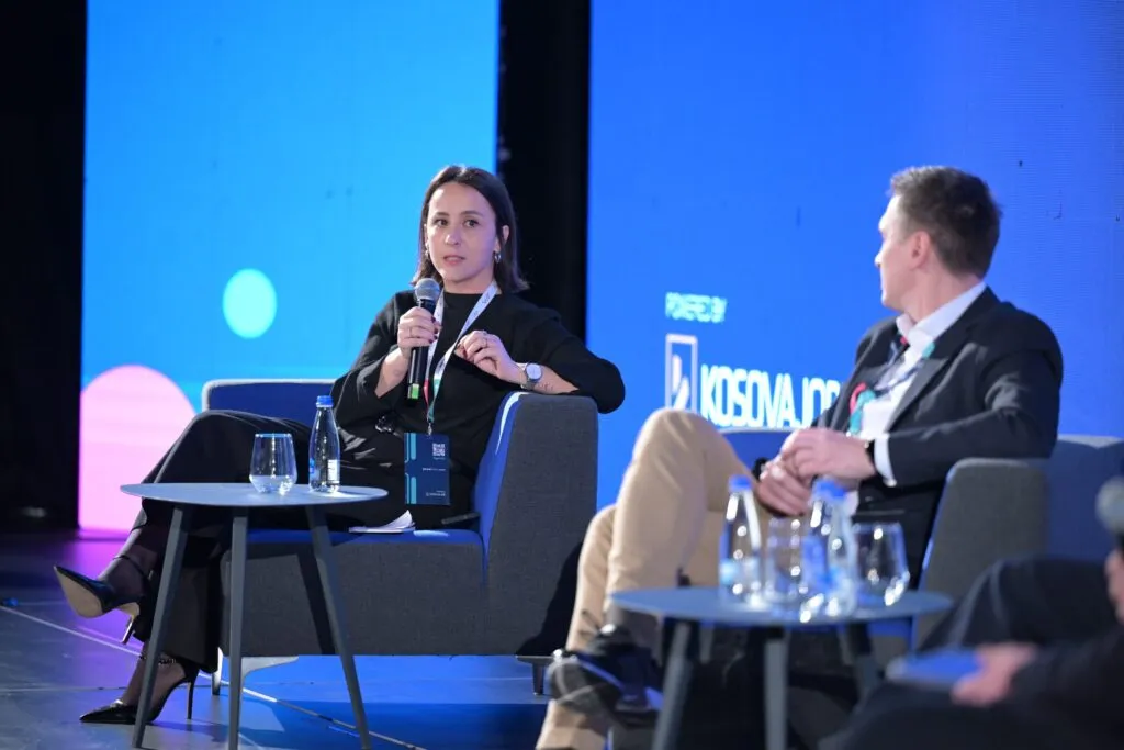 Hana Qerimi speaks on a panel at the Power2HR summit, KosovaJob’s name on the screen behind